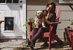 Genest and her dog enjoy the porch on the home she purchased with the help of a UFCU mortgage loan.