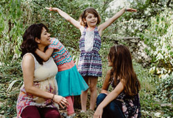 Ariana and her daughters share a moment in Mayfield park.