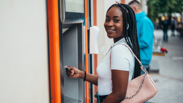 Young woman using ATM.