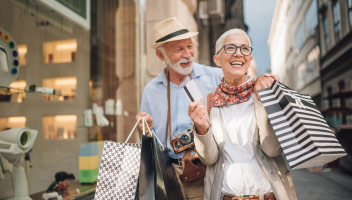 Happy couple carrying many shopping bags.