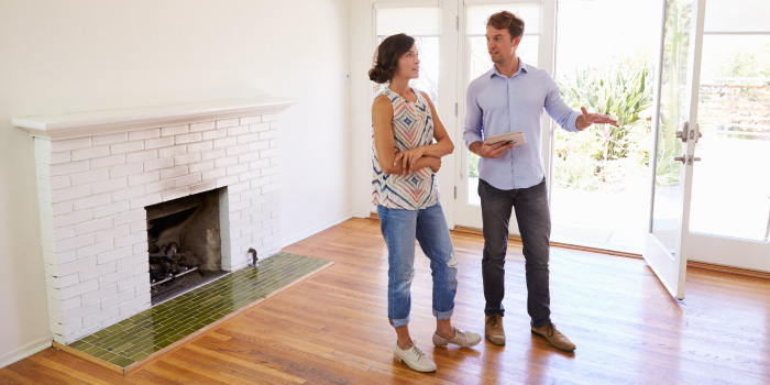 Male Realtor Showing Female Client Around House